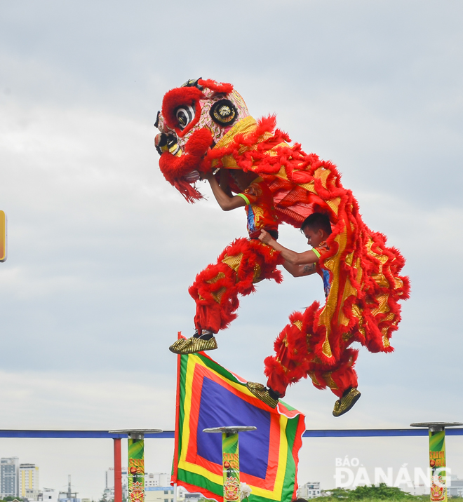  Dancers enthralling the audience with their jaw-dropping stunts on the row of poles during a fierce yet graceful lion dance