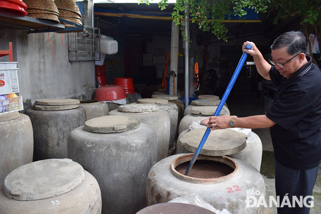 Vats of fish sauce at a production facility in the Nam O Village