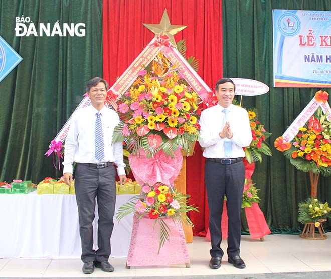 Phó Chủ tịch UBND thành phố Lê Trung Chinh tặng hoa chúc mừng thầy và trò Trường THCS Đỗ Đăng Tuyển. Ảnh: NGỌC PHÚ