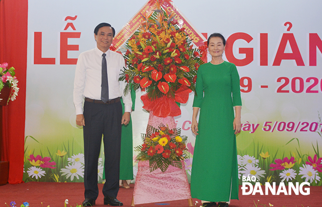 Vice Chairman Mien (left) congratulating teachers and pupils of the Duc Tri Kindergarten-Primary-Junior High School on the occasion of the new school year