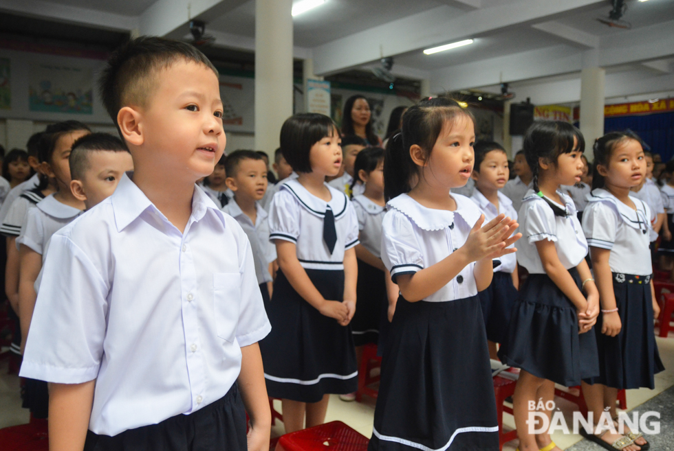 Little pupils singing the national anthem in a solemn atmosphere