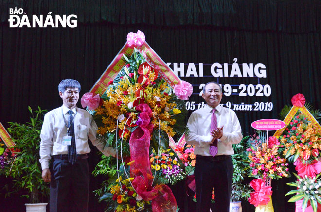 Bí thư Thành ủy Trương Quang Nghĩa (phải) tặng hoa chúc mừng thầy và trò Trường THPT Chuyên Lê Quý Đôn. Ảnh: NGỌC PHÚ