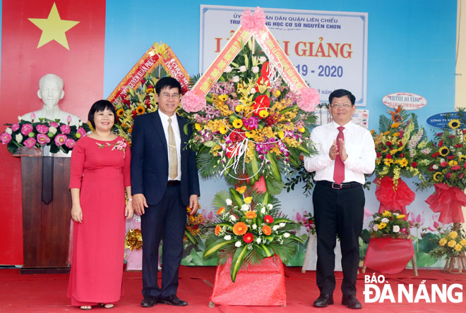 Phó Bí thư Thường trực Thành ủy Võ Công Trí (phải) tặng hoa chúc mừng thầy và trò Trường THCS Nguyễn Chơn. Ảnh: NGỌC HÀ