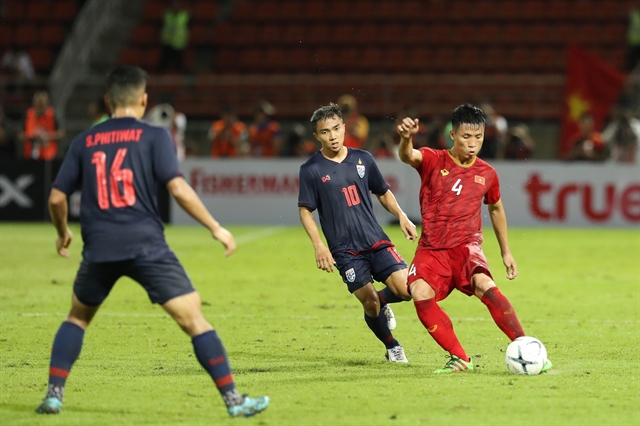 Việt Nam's defender Bùi Tiến Dũng is surrounded by Thai players during their 2022 World Cup qualifier yesterday in Thailand. The match ends 0-0. VNA/VNS Photo Trọng Đạt Read more at http://vietnamnews.vn/sports/535016/road-to-qatar-starts-with-valuable-draw.html#DWfrWiSoqeA9iLgu.99