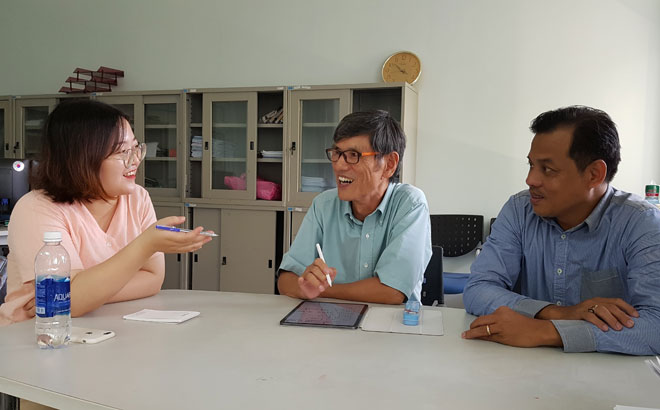 Mr Lee Chando (centre) reading the English online edition of the Da Nang Newspaper every morning