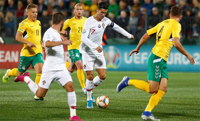 Ronaldo đi bóng trong vòng vây của các cầu thủ Lithuania.