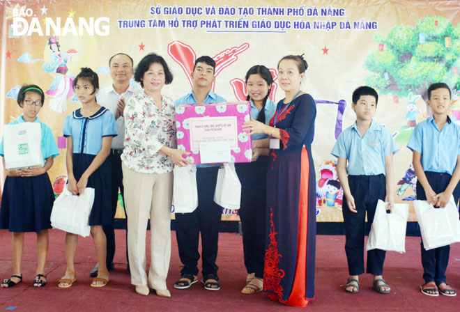 Chủ tịch Ủy ban MTTQ Việt Nam thành phố Đặng Thị Kim Liên tặng quà Trung tâm Hỗ trợ phát triển giáo dục hòa nhập Đà Nẵng. 			Ảnh: LÊ VĂN THƠM