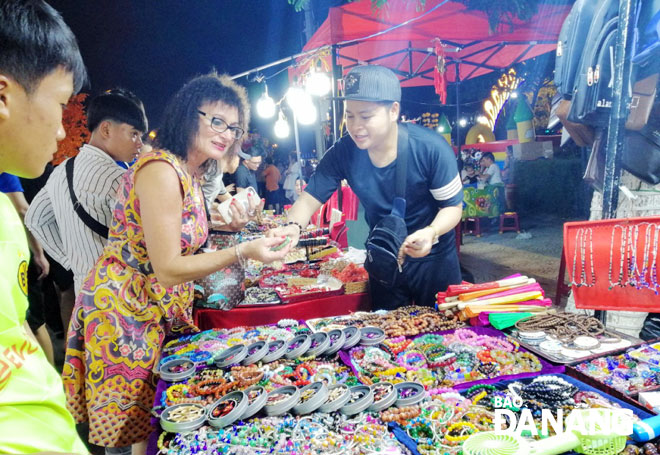 Đẩy mạnh các sản phẩm du lịch về đêm cũng là một cách để thu hút, giữ chân khách quốc tế.  Trong ảnh: Khách du lịch quốc tế mua sắm tại chợ đêm Sơn Trà.