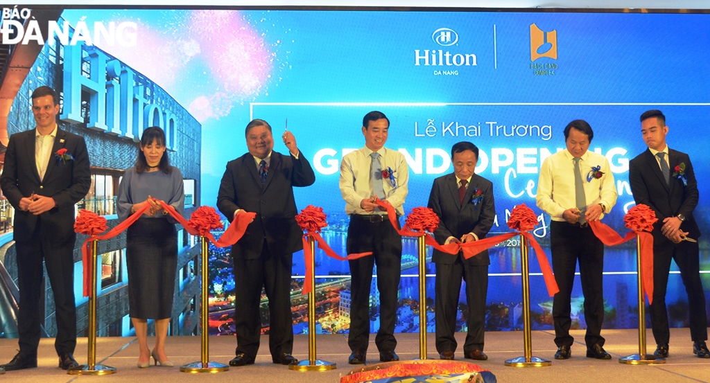 Vice Chairman of the municipal People’s Committee Le Trung Chinh (centre) and other delegates cutting the ribbon-cutting ceremony for the Hilton Da Nang