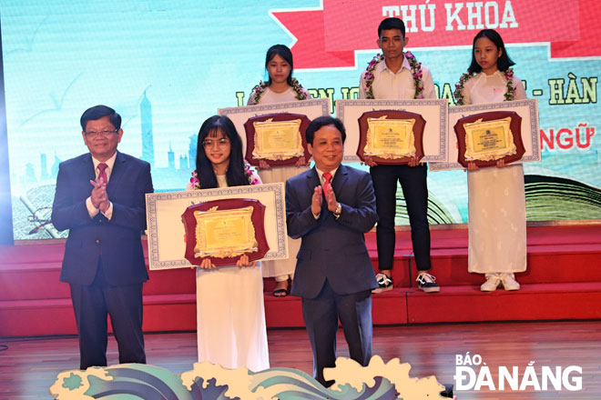 Municipal Party Committee Deputy Secretary Vo Cong Tri (left) honouring UDN’s top scoring students