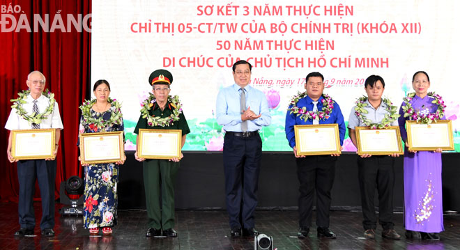 Chủ tịch UBND thành phố Huỳnh Đức Thơ (giữa) tặng Bằng khen cho các cá nhân điển hình tiêu biểu.  			              Ảnh: ĐẶNG NỞ