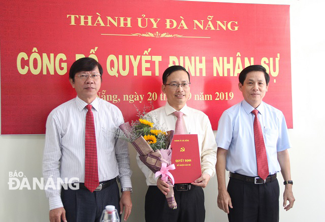 Trưởng ban Tổ chức Thành ủy Võ Văn Thương (bìa trái) và Bí thư Đảng ủy Khối các cơ quan thành phố Phạm Tấn Xử (bìa phải) trao quyết định của Ban Thường vụ Thành ủy cho ông Hà Đức Hoài. Ảnh: LAM PHƯƠNG