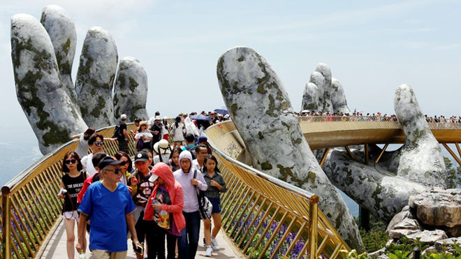 Khách du lịch đi bộ trên cầu Vàng gần trung tâm thành phố Đà Nẵng. Đất nước này đã thu hút nhiều người Hàn Quốc trong những tháng gần đây. Ảnh: Reuters