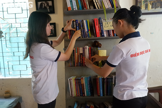 Thành viên của dự án Điểm đọc Việt Nam - Đà Nẵng đang sắp xếp lại sách tại trạm đọc ở quán Lữ.