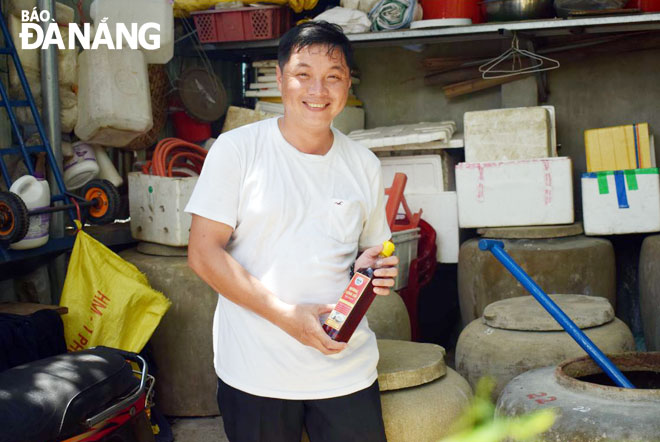 Doanh nhân Bùi Thanh Phú bên sản phẩm nước mắm mang hồn cốt của làng nghề làm mắm truyền thống Nam Ô. 