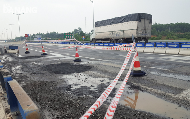 The potholes at the intersection being patched with cold asphalt concrete