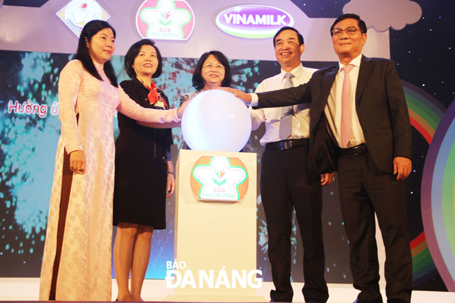 Phó Chủ tịch nước Đặng Thị Ngọc Thịnh (giữa), Phó Chủ tịch UBND thành phố Lê Trung Chinh (thứ hai từ phải sang) bấm nút phát động chương trình Sữa học đường năm học 2019-2020. 