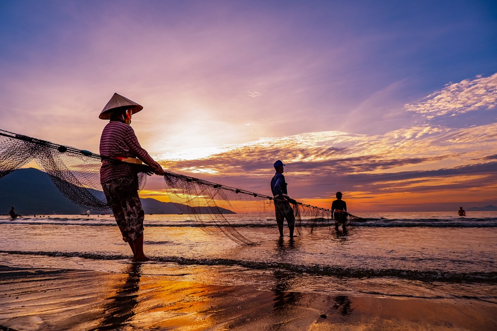 Fishermen pulling in fishing nets in an early morning