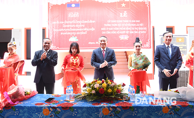 Secretary Nghia (3rd right) and Vice Chairman Mien (1st right) participating in the ribbon cutting ceremony for the Attapeu Friendship Junior High School