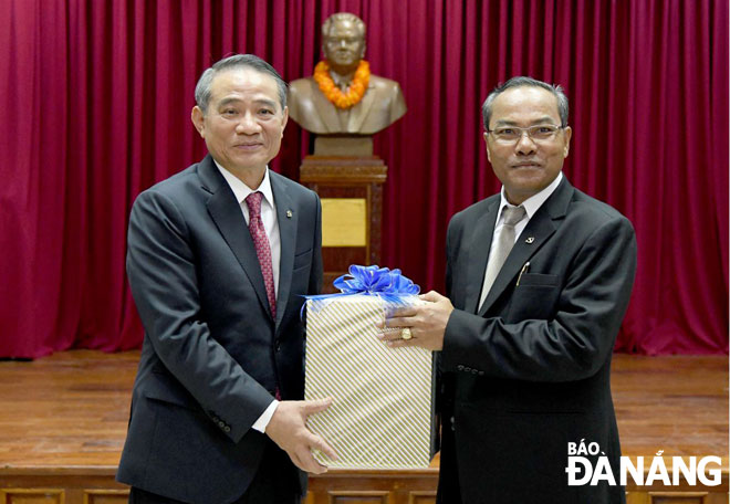 Bí thư Thành ủy Trương Quang Nghĩa  (bên trái) tặng quà lưu niệm cho đồng chí Let Xaynhaphon, Bí thư Tỉnh ủy, Tỉnh trưởng tỉnh Attapeu. Ảnh: ĐẶNG NỞ