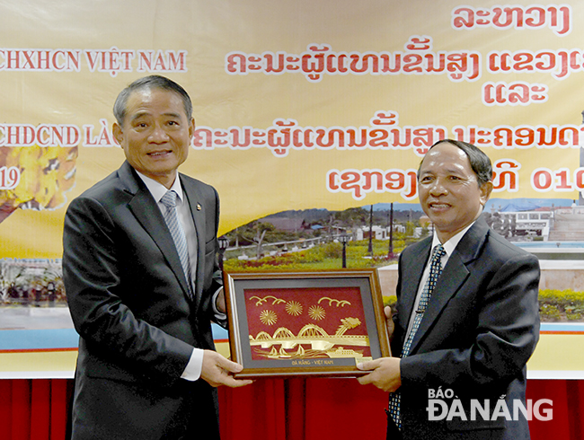 Bí thư Thành ủy Trương Quang Nghĩa (bìa trái) tặng quà lưu niệm cho đồng chí Sekong Khamphoi Butdavieng. Ảnh: ĐẶNG NỞ