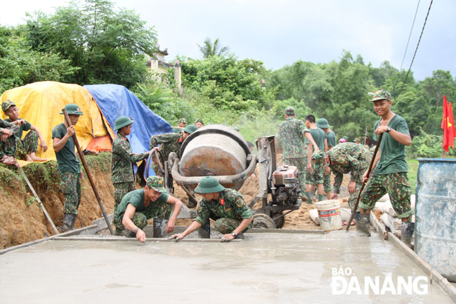 Lực lượng quân đội giúp các xã của huyện Hòa Vang xây dựng đường bê-tông nông thôn. Ảnh: L.PHƯƠNG