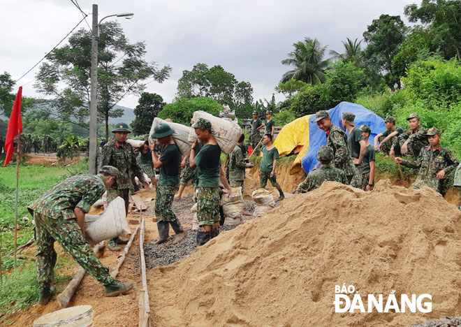Các lực lượng quân đội giúp các xã của huyện Hòa Vang xây dựng đường bê-tông nông thôn. Ảnh: L.PHƯƠNG
