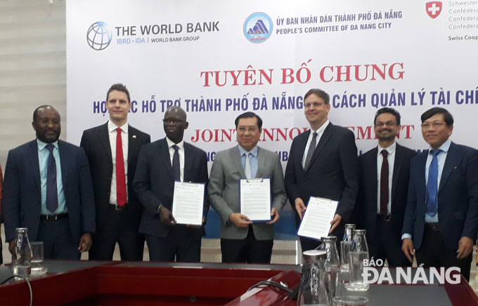 Chủ tịch UBND thành phố Đà Nẵng Huỳnh Đức Thơ (giữa) tiếp nhận chương trình hỗ trợ cải cách quản lý tài chính công từ Tổng Cục Kinh tế Liên bang Thụy Sỹ thông qua Ngân hành Thế giới