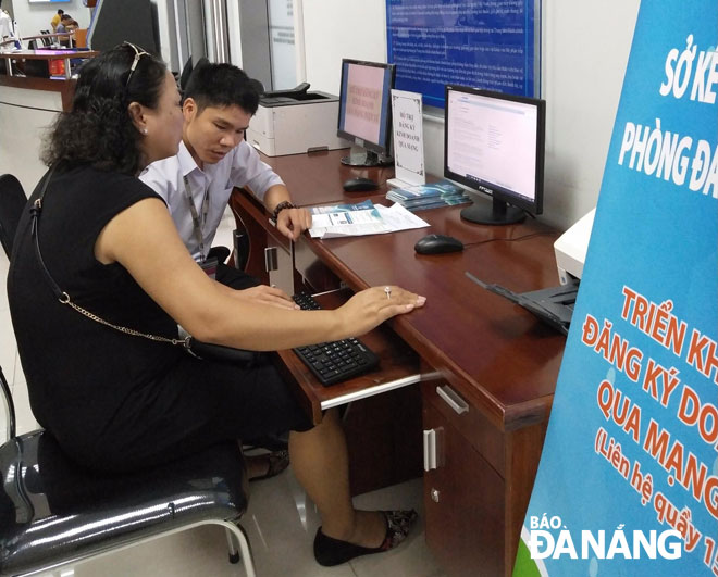 An employee from the municipal Department of Planning and Investment assisting a resident to register business online   