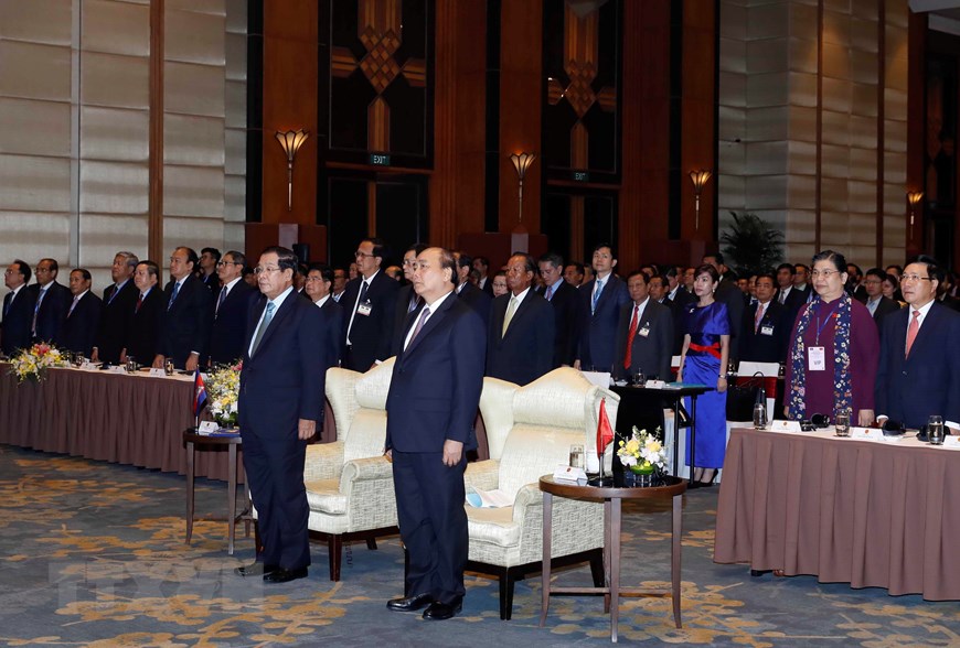 Thủ tướng Nguyễn Xuân Phúc và Thủ tướng Vương quốc Campuchia Samdech Techo Hun Sen và các đại biểu thực hiện nghi thức chào cờ. (Ảnh: Thống Nhất/TTXVN)