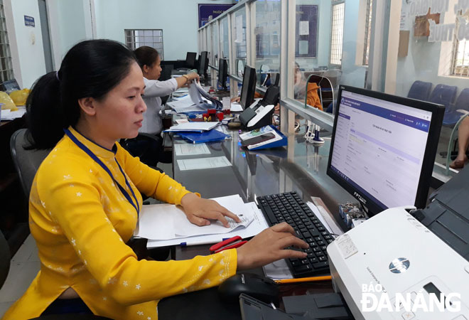 Nhân viên bưu điện Trần Thị Khánh Vân tiếp nhận hồ sơ hành chính tại bộ phận “một cửa” của quận Sơn Trà. 