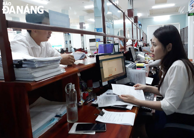Nhân viên bưu điện Vũ Thị Kim Phượng đã thành thạo việc hướng dẫn thủ tục và tiếp nhận hồ sơ hành chính tại bộ phận “một cửa” của quận Thanh Khê.