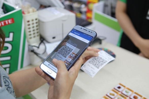 A customer makes payment by QR code at a supermarket (Photo: VNA)