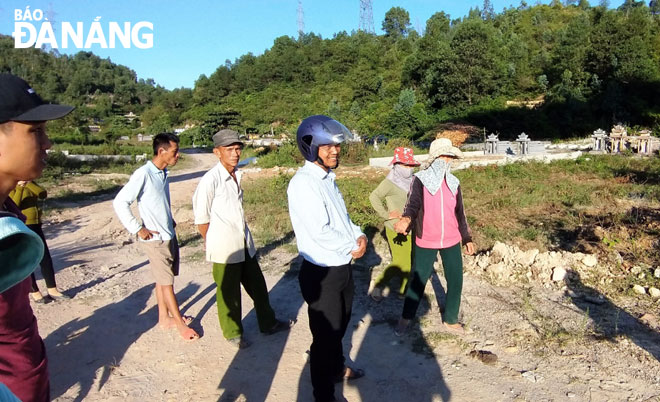 Mr Ngo Thanh Tam, Vice Chairman of the Hoa Lien Commune People’s Committee (in white shirt and helmet) talking to local residents about burying ASF-infected pigs at the Ho Ba Tuong Cemetery. 