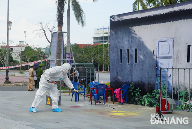 An employee using a specialised stick to clean up a contaminated area