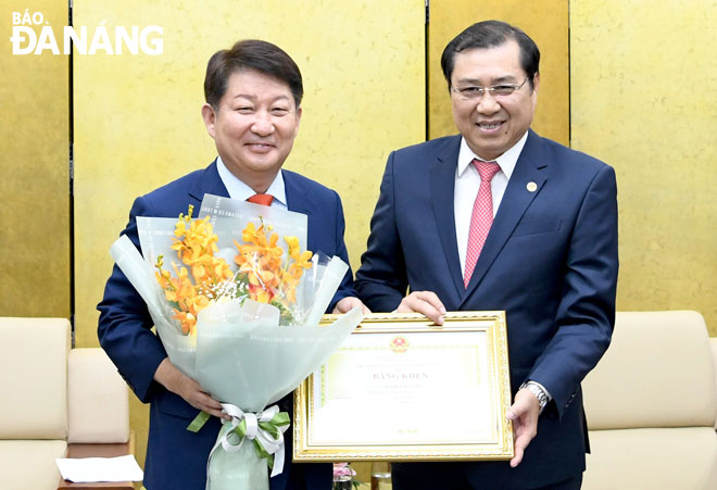 Photo: Chairman of Da Nang People's Committee Huynh Duc Tho (right) presenting a Certificate of Merit to Mayor Kwon Young-jin