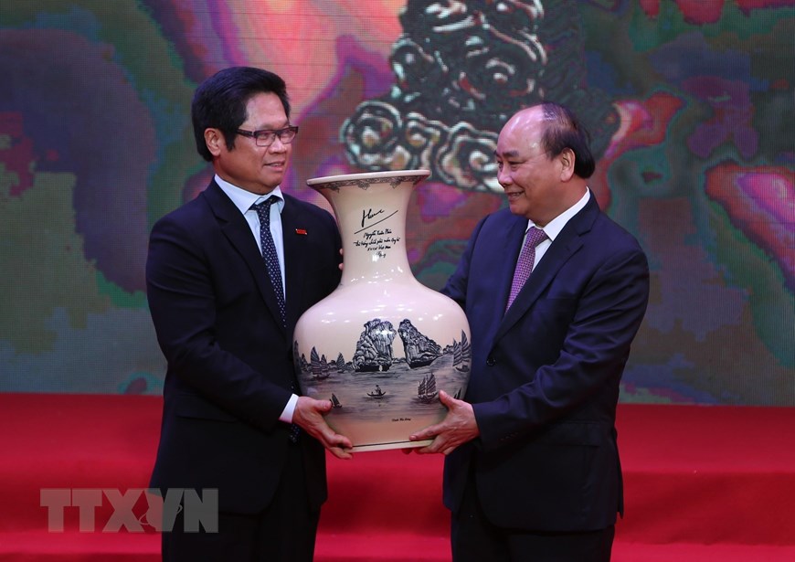  Chủ tịch Phòng Thương mại và Công nghiệp Việt Nam Vũ Tiến Lộc, đại diện các doanh nhân nhận quà tặng của Thủ tướng Nguyễn Xuân Phúc. (Ảnh: Dương Giang/TTXVN)