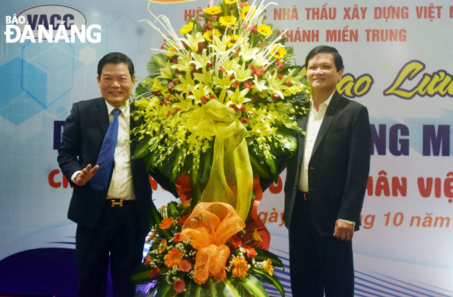 Chủ tịch HĐND thành phố Nguyễn Nho Trung (phải) tặng hoa chúc mừng Hiệp hội các nhà thầu xây dựng Việt Nam, chi nhánh miền Trung.              Ảnh: TRIỆU TÙNG