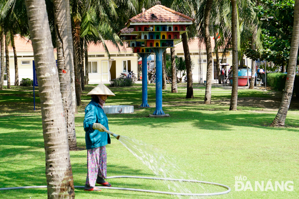 A woman watering grass