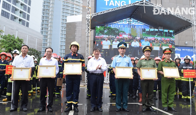 Phó Chủ tịch Thường trực UBND thành phố Đặng Việt Dũng (giữa) tặng bằng khen cho các tập thể, cá nhân có thành tích xuất sắc trong cuộc diễn tập.