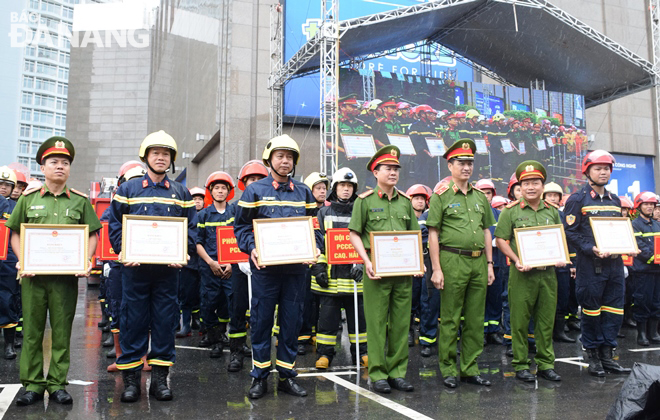 Deputy Minister of Public Security Nguyen Duy Ngoc (3rd, right) presenting Certificates of Merit to outstanding individuals and groups during the practice