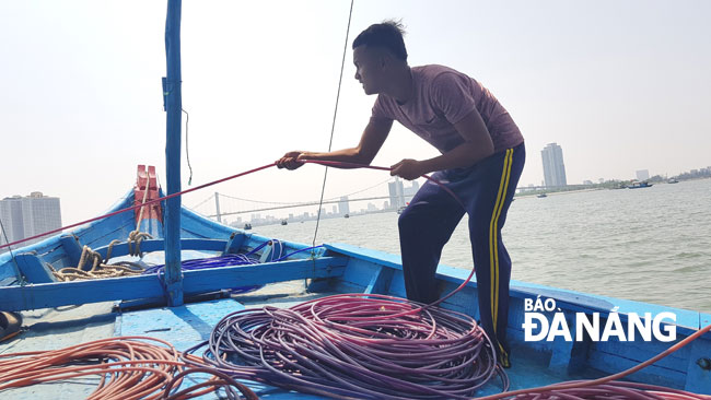 Apart from divers, there is a person who is responsible for keeping breathing tubes for divers in order to ensure that the tubes are not bent. In the picture,  16-year-old Le Hoang Phu from Nai Hien Dong Ward pulling a breathing tube for chip chip divers with a daily wage of 300,000 VND.