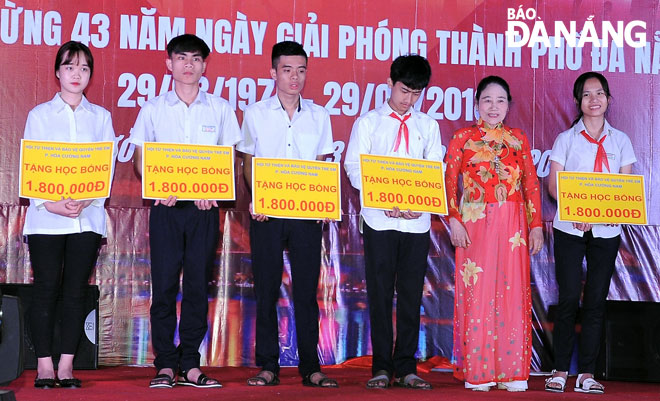 Bà Nguyễn Thị Nam Hồng (thứ 2, phải sang) trao học bổng cho học sinh nghèo vượt khó. 