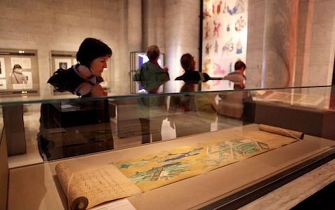 Một du khách đang xem Câu chuyện về Genji của Murasaki Shikibu, từ năm 1580, tại Thư viện Công cộng New York.