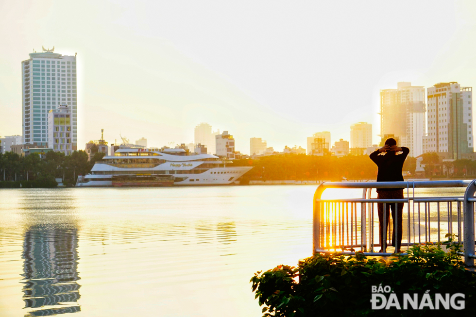 Warm glow from the rising sun pouring through riverside houses