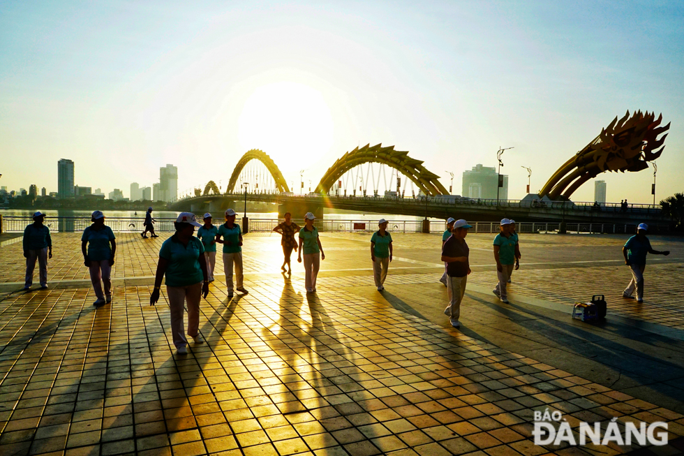 A group of elderly people doing physical exercise at a park near the western end of the Rong (Dragon) Bridge