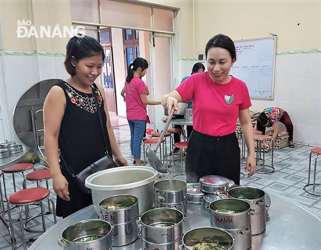 Mỗi tháng 3-4 lần, chị Huyền (phải) tổ chức nấu và phát hàng nghìn suất ăn miễn phí.