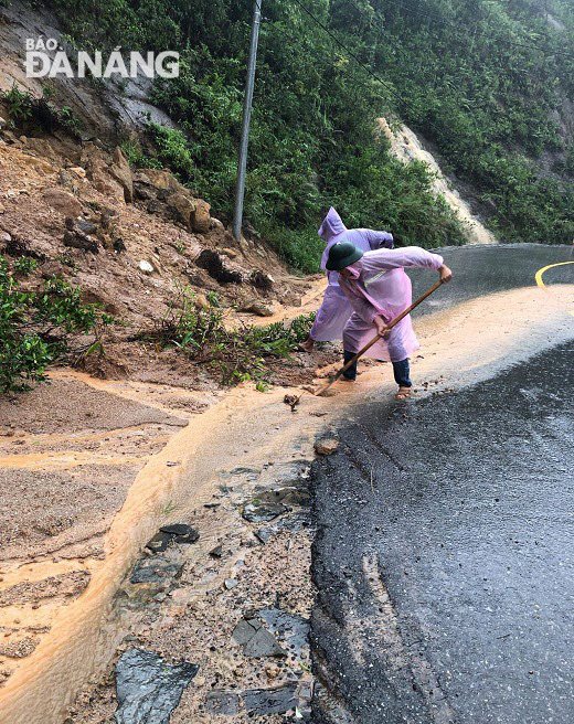 Công nhân Công ty Quản lý Cầu đường Đà Nẵng tham gia khắc phục sạt lở trên tuyến đường lên Bán đảo Sơn Trà. Ảnh: NAM PHƯƠNG.