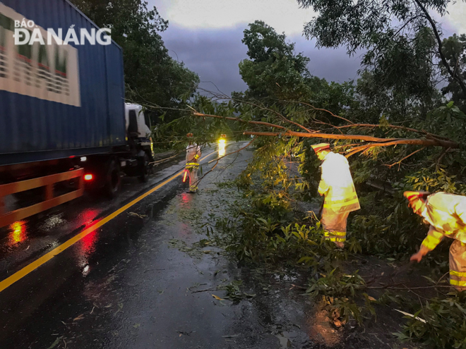  Local traffic police getting actively involved in clearing the mess caused by falling trees on a section of the National Highway 1A which runs through Hoa Phuoc Commune….