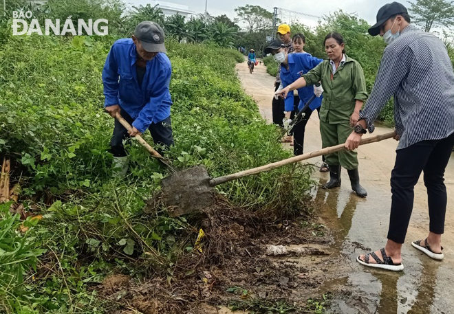 Người dân xã Hòa Châu dọn vệ sinh môi trường và khơi thông thoát nước.